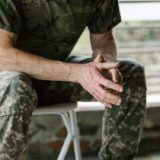 A contemplating serviceman sitting on a chair