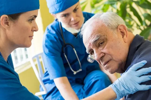 An old man being forced to accept medical treatment in a nursing home.