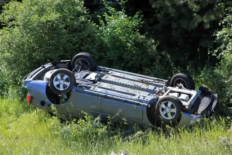 A car rollover accident by the side of the road.