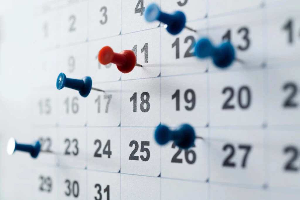 Thumbtacks marking a calendar to follow the workers' comp 90-day rule.
