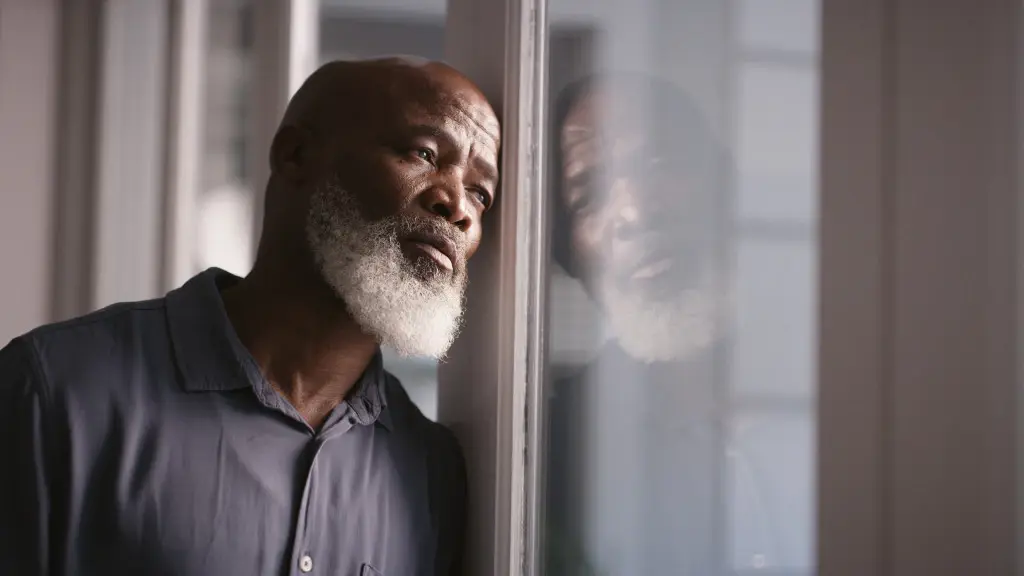 An old man with a white beard leaning on a window. Find a nursing home abuse in Florida to represent you.