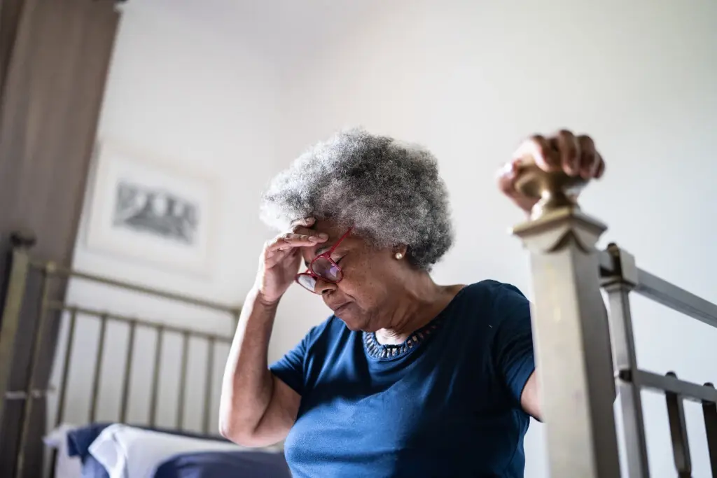 An old woman sitting down on a bed, suffering nursing home abuse in Wisconsin