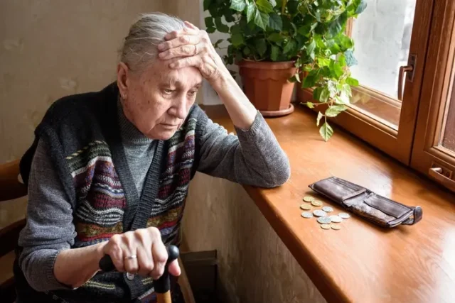 An old person suffering nursing home financial abuse looking at a wallet