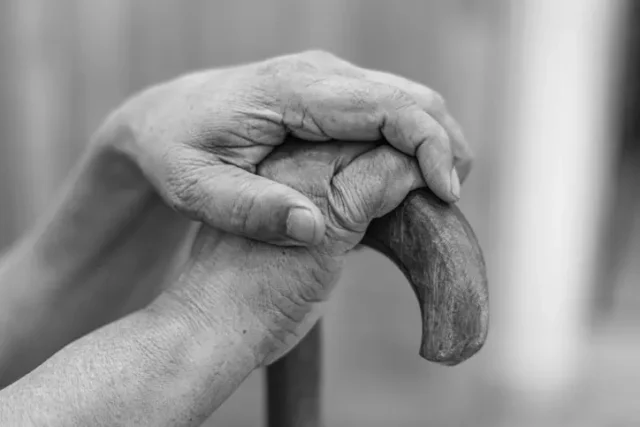 An old person holding a cane, suffering nursing home abuse in Arizona.