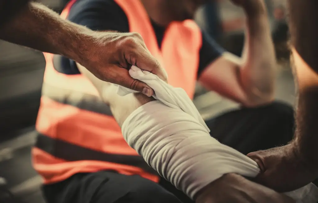 A factory worker suffering an industrial injury on their arm.