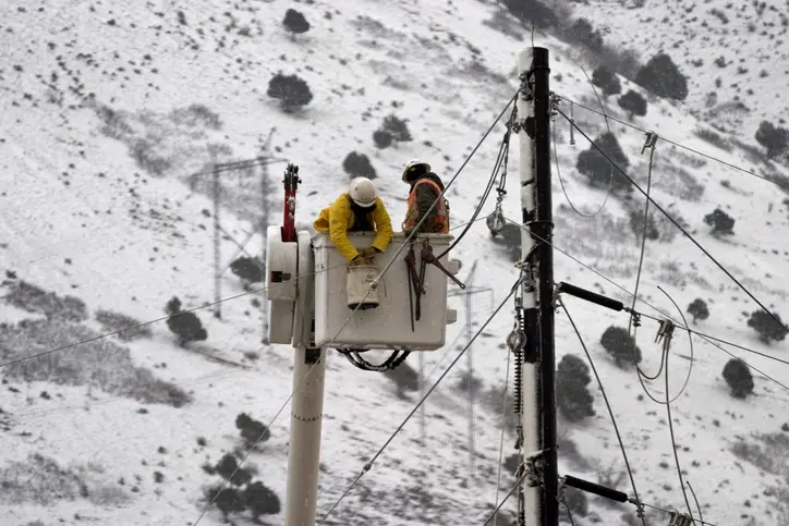 A pair of electricians working under extreme cold.